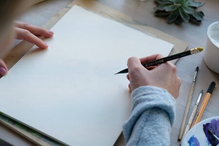 woman painting flower with a pencil at her workplace. close upの写真素材