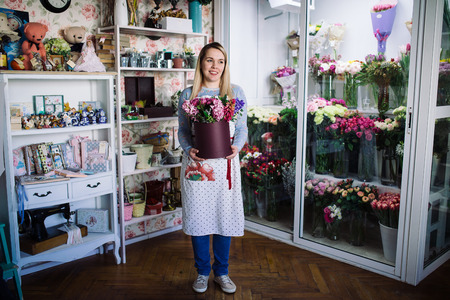woman florist holding bouquet of hyacinth indoor in flower shopの写真素材