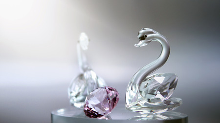 Isolated crystal glass swans with pink diamondの写真素材