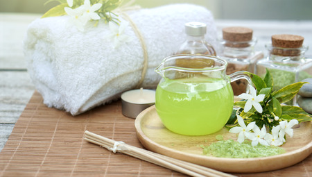 Green spa setting on bamboo mat and wooden tableの写真素材