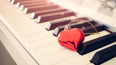 Red glossy heart on piano keyboard, love and vintage conceptの写真素材