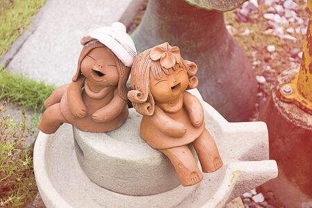 Earthenware or ceramics kid doll smile/laugh and sitting in garden. happy moment action.の写真素材