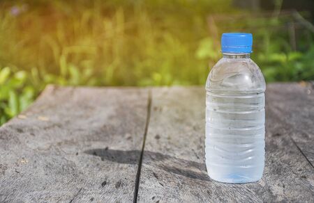 bottle on wooden table texture with nature background.  scene of summer season. Fresh concept.の写真素材