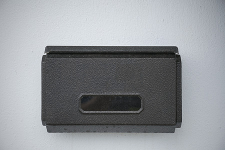 Black mail box in rectangular shape on wall.の写真素材