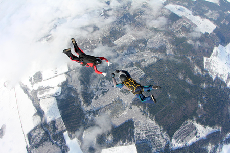 Two skydivers in the winter sky.の写真素材
