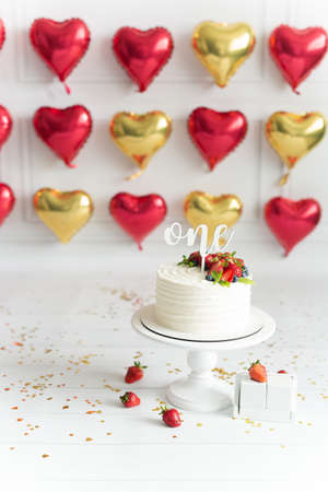 Festive location with the first birthday cake white background with yellow sparkles in the form of a...