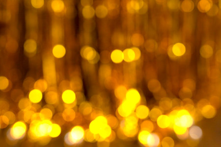 Festive golden rain blur background with lights. Celebration and decoration conceptの写真素材