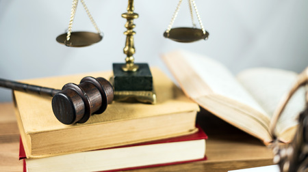 Gavel and legal book on wooden table