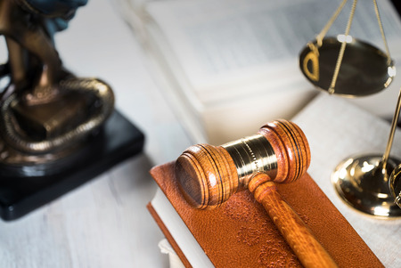 Law theme, mallet of the judge, wooden desk, books