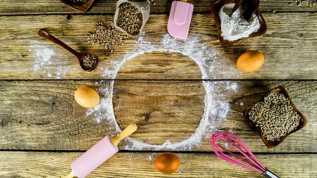 Different bread, wheat and milk on a wooden table