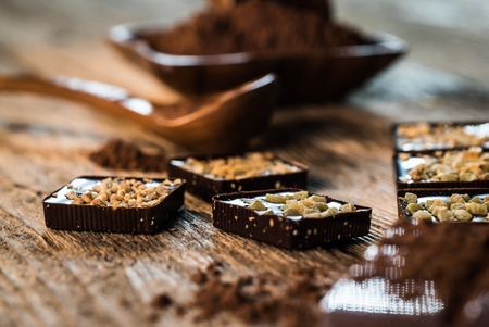 Broken chocolate bar and spices on wooden table. Selective focus