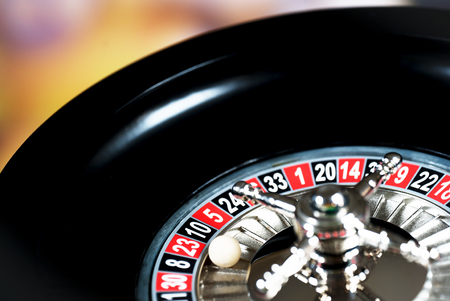 High contrast image of casino roulette and poker chips on bokeh background.の写真素材