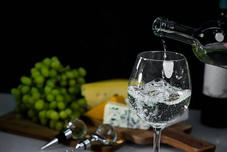 Cropped view sommelier pouring wite wine from bottle into glassの写真素材