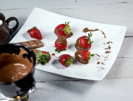Chocolate fondue with fresh berries on wooden tableの写真素材