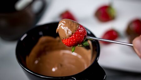 Chocolate fondue with fresh berries on wooden tableの写真素材