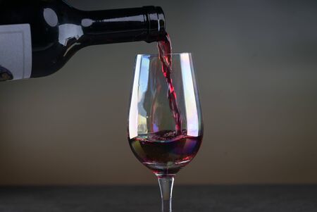 Red wine being poured into a glass close-upの写真素材