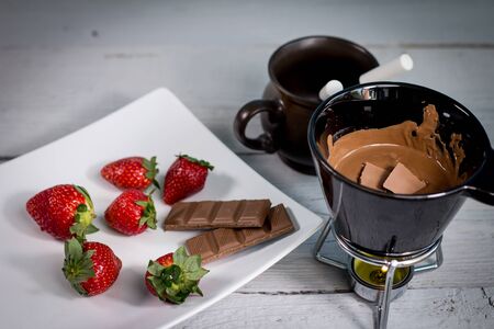 Chocolate fondue with fresh berries on wooden tableの写真素材