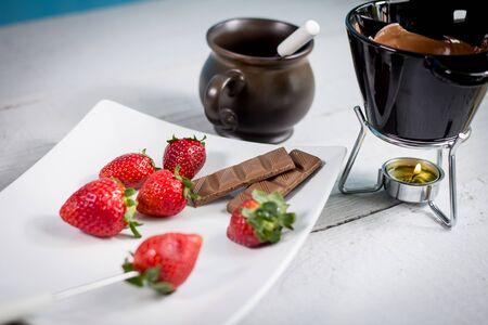Chocolate fondue with fresh berries on wooden tableの写真素材