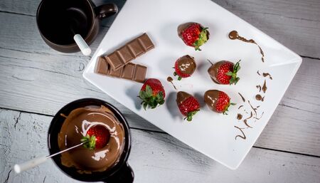 Chocolate fondue with fresh berries on wooden tableの写真素材