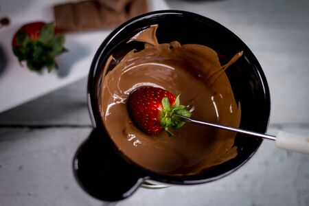 Chocolate fondue with fresh berries on wooden tableの写真素材