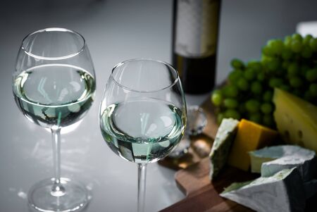 Pouring red wine from a bottle into a wineglass: wine tasting and celebrationの写真素材