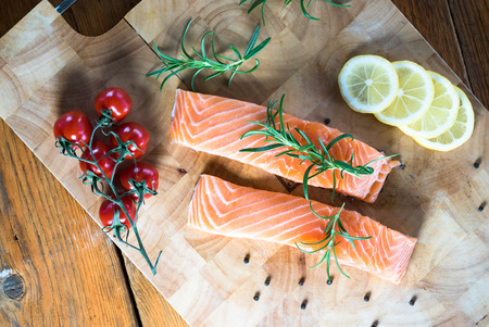 Salmon Fish..Raw salmon fillet pepper salt dill lemon rosemary on wooden table.