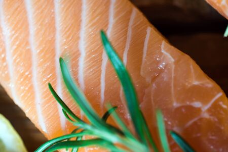 Salmon Fish..Raw salmon fillet pepper salt dill lemon rosemary on wooden table.の写真素材