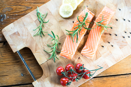 Salmon Fish..Raw salmon fillet pepper salt dill lemon rosemary on wooden table.の写真素材