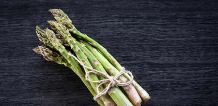 Fresh green asparagus on a stone worktopの写真素材