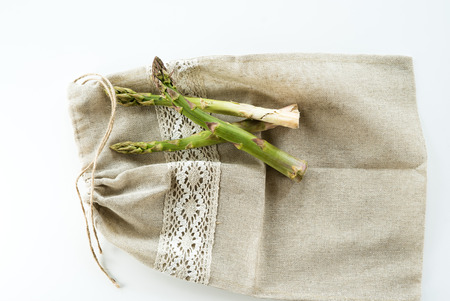 Bundle of fresh green asparagus on a white table with copy space.の写真素材