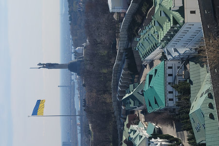 Panoramic view of Kyiv city with national flag and Dnipro river under blue sky. Urban landscape with historic architecture.の写真素材