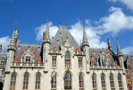 Medieval City Hall building with local districts flags in historical center of Brugge, Belgiumのeditorial素材