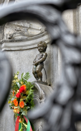 BRUSSELS, BELGIUM-SEPTEMBER 21: Manneken Pis with flowers behind fence before ceremony of award of costume on September 21, 2013 in Brussels, Belgiumのeditorial素材