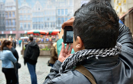 BRUSSELS, BELGIUM-OCTOBER 23, 2014: Cold weather does not stop tourists from crowding historical center of Brussels. Foreign tourist takes pictures on Grand Placeのeditorial素材