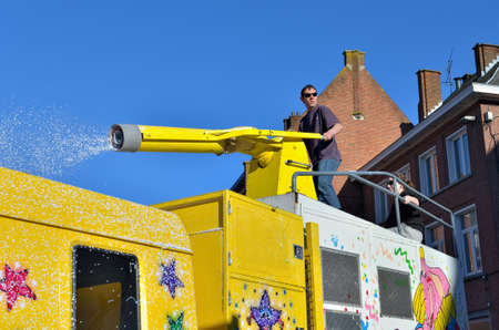 NIVELLES, BELGIUM-MARCH 03, 2014: Unidentified participant throws artificial snow to public during parade of yearly carnival in Nivellesのeditorial素材