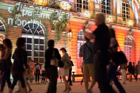 NANCY, FRANCE - JULY 06, 2013: Tourists arrive to Place Stanislas in historical center of Nancy in late evening to see its night illumination. This square is in World Heritage Sites list of UNESCO since 1983.のeditorial素材