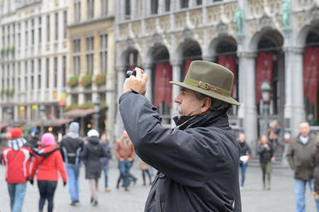 BRUSSELS, BELGIUM-DECEMBER 05, 2014: Tourist taking pictures on Grand Place in Brussels, mostly popular popular attraction in the cityのeditorial素材