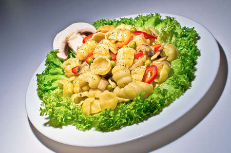 Pasta with mushrooms, bacon, pea pods and saladの写真素材