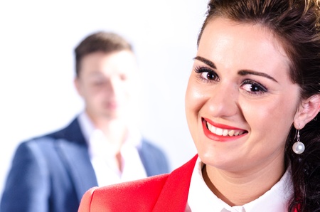 Portrait of young business woman with her colleague at the back against white backgroundの写真素材