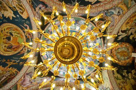 Golden chandelier on the top to an orthodox church ceiling