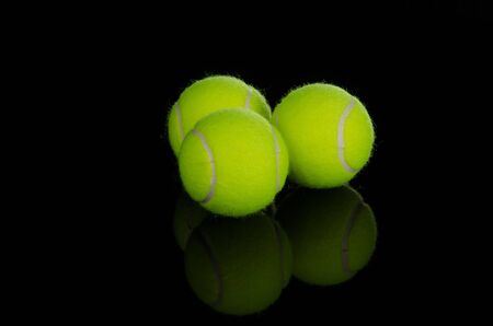 Tennis balls  against a black backgroundの写真素材