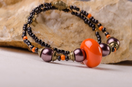 Handmade jewellery and a stone on white backgroundの写真素材