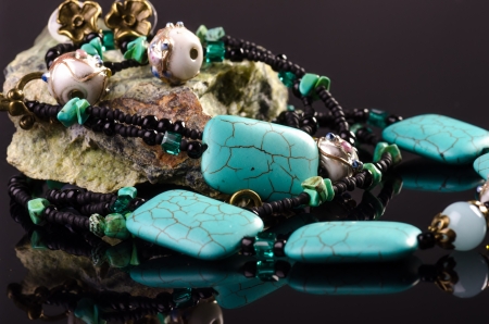 Handmade jewellery necklace and earings against black backgroundの写真素材