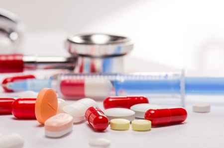 Pills, syringe  and stethoscope against white backgroundの写真素材