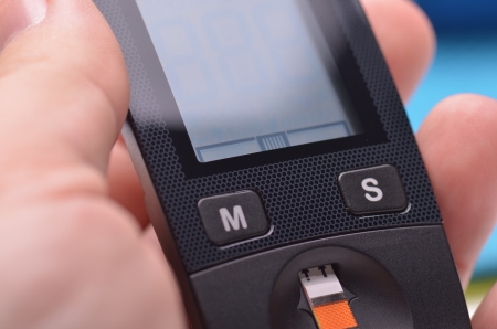 Blood glucose meter display on blue surfaceの写真素材