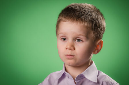 Portrait of child wondering against green background