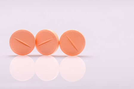 Orange pills on white surfaceの写真素材