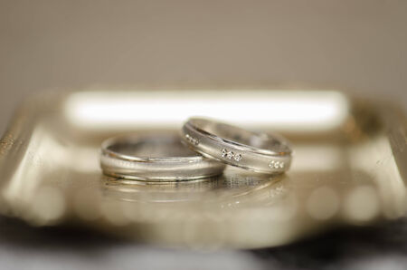Wedding rings on a golden plate against a dark の写真素材