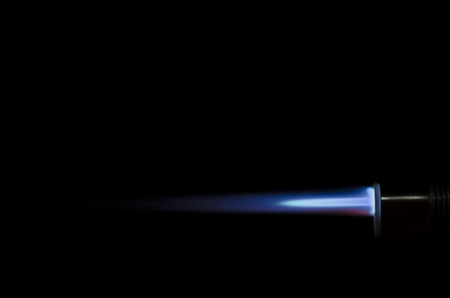Blue torch flame against black background
