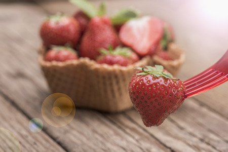 Strawberries in ice cream cup against a wooden backgroundの写真素材